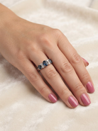 hand An 18 carat white gold * dress ring. Features three large sapphires, centre 8x6mm (est 1.25 carats) and each side a 7x5mm sapphire (est 0.75 carats), dark blue hues, with slight green tinges to edges.