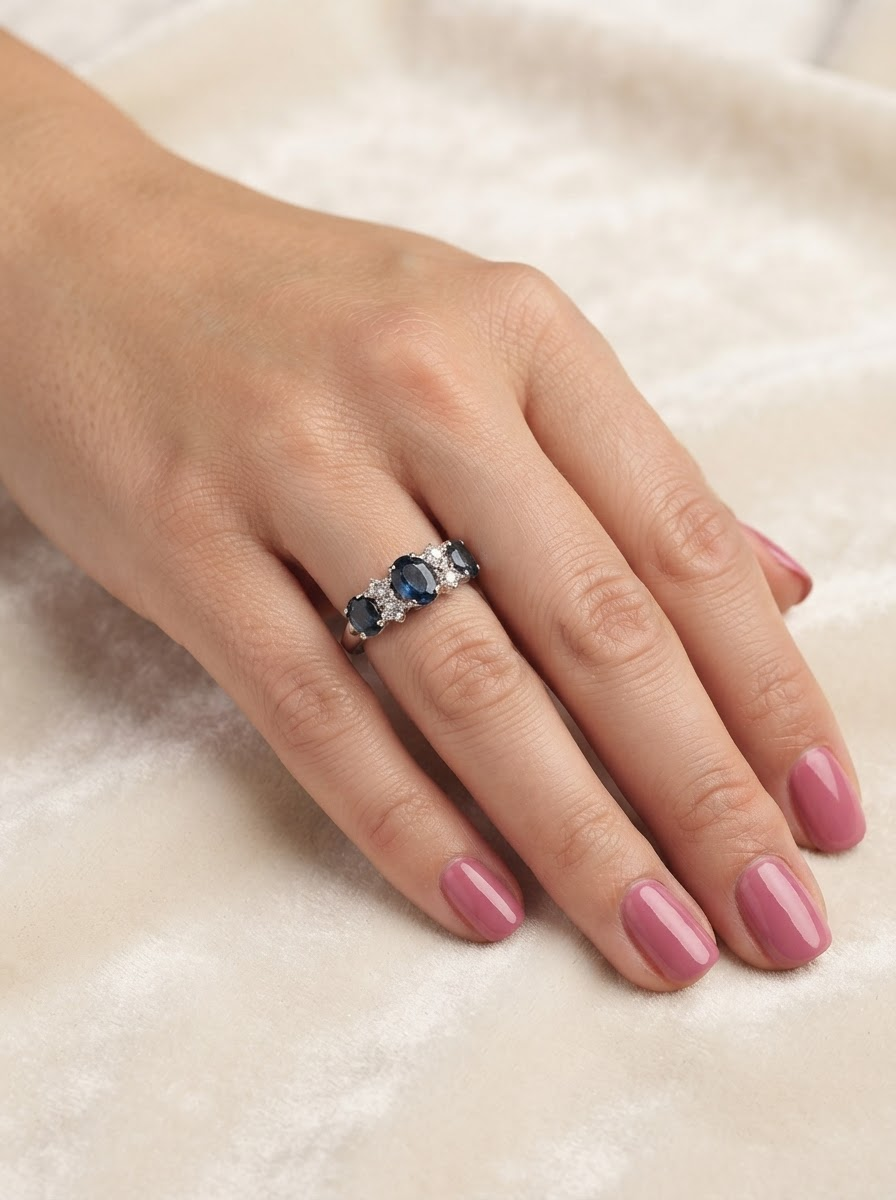 hand An 18 carat white gold * dress ring. Features three large sapphires, centre 8x6mm (est 1.25 carats) and each side a 7x5mm sapphire (est 0.75 carats), dark blue hues, with slight green tinges to edges.
