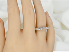 hand An 18 carat white gold half hoop eternity ring. Set with seven brilliant cut white diamonds,