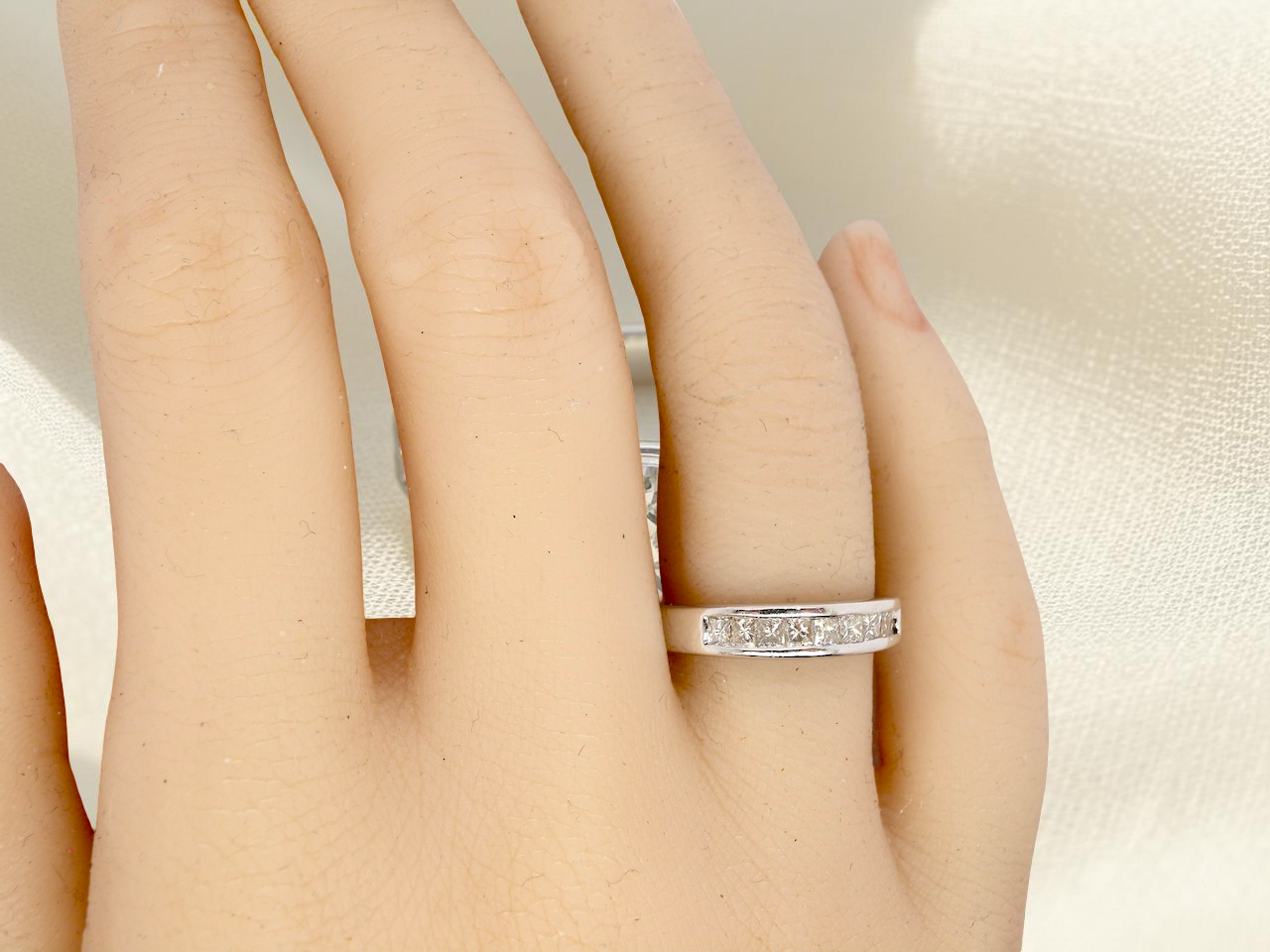 hand An elegant half-hoop eternity ring set with nine princess-cut white diamonds, each measuring approximately 2.5mm, with a total estimated diamond weight of 0.90 carats.