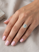 hand An impressive cluster ring that features to the centre an oval cut blue topaz gemstone, 8x6mm sky blue colour.

Complimented by an outer double halo of diamonds