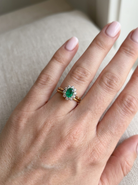 hand Features an oval cut emerald centre stone, vibrant green hues, measures 9x6mm(est 1.75 carats) . Complimented by an outer halo of ten 2.7mm brilliant cut white diamonds (est total 0.60 carats) colour i-j, clarity S.
