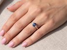 hand The iconic trilogy ring, featuring an oval cut sapphire centre stone, with a pleasing mid blue hue set into four claws, 7x5mm (0.75 carats est)