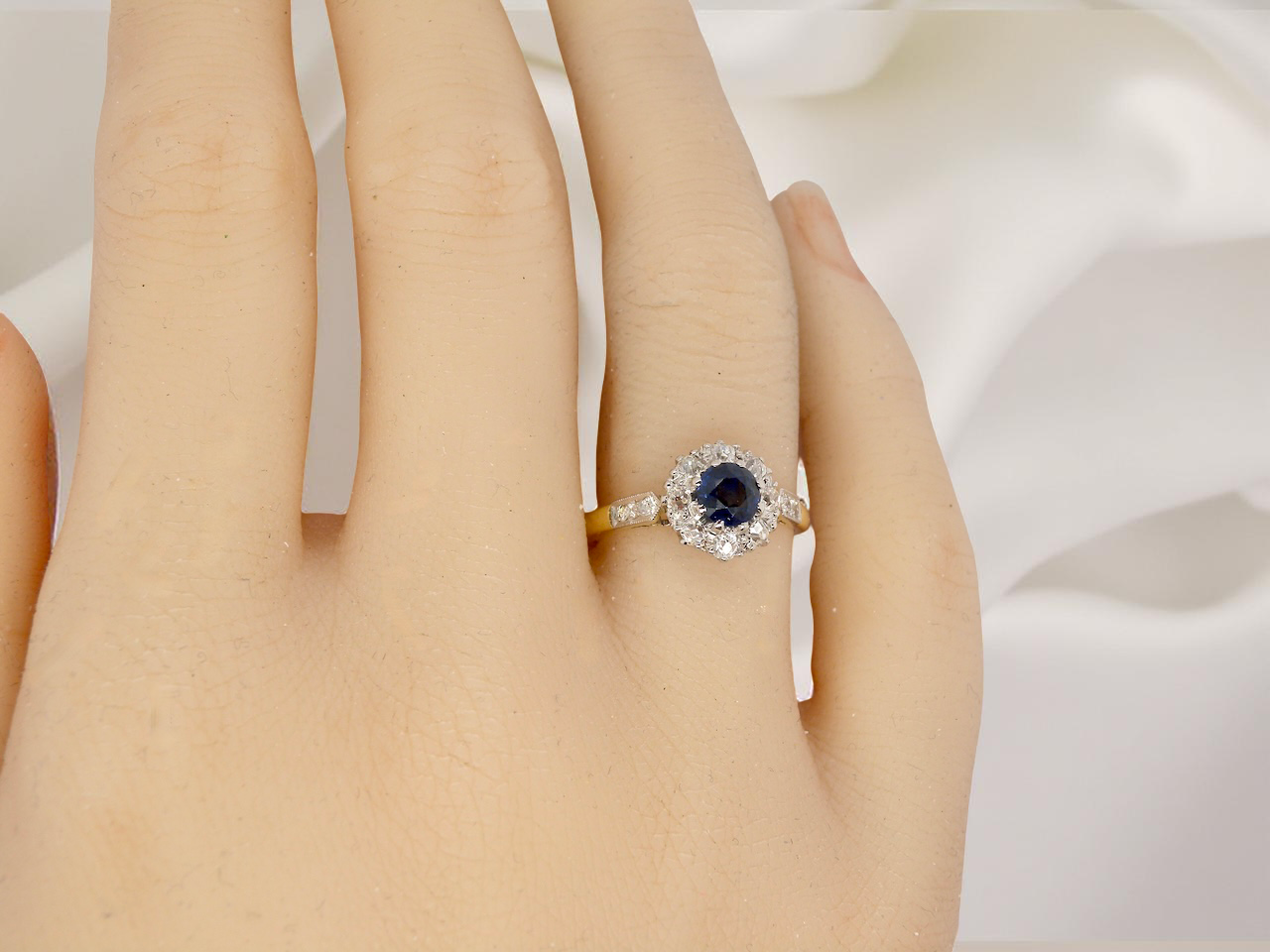 hand  beautiful mid-century cluster ring featuring a round dark blue sapphire 