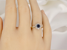 hand  beautiful mid-century cluster ring featuring a round dark blue sapphire 