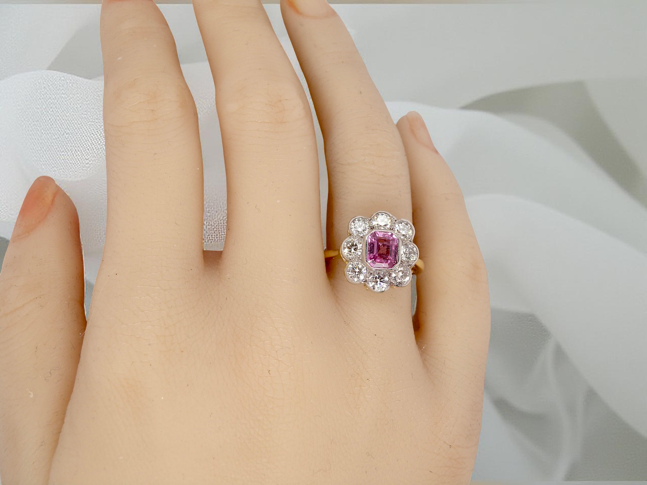hand  cluster ring featuring a beautiful cushion-cut pink sapphire 