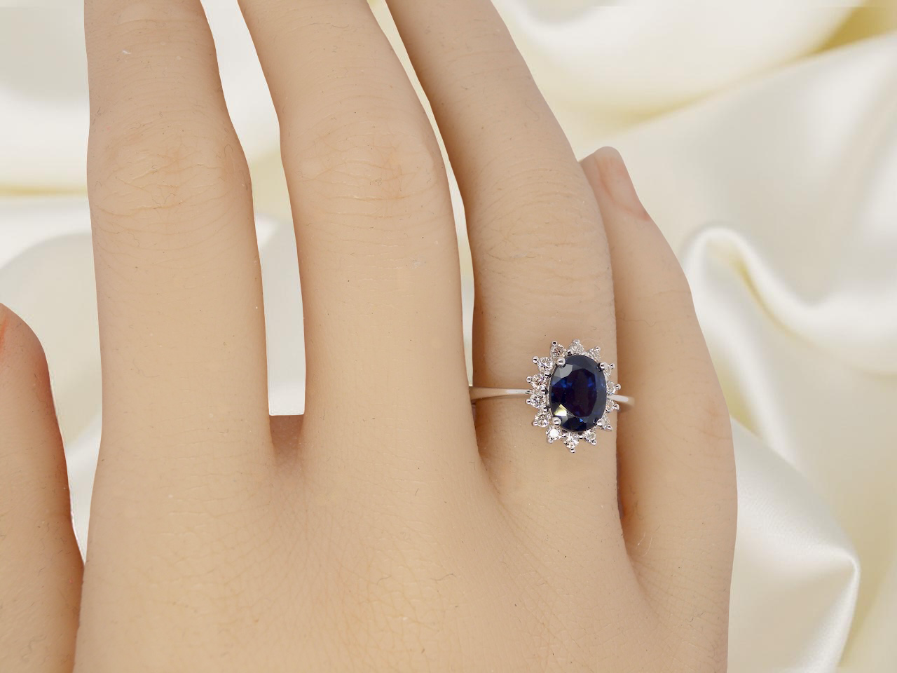 hand cluster ring featuring a striking mid–dark blue oval-cut sapphire at its centre, measuring approximately 8 × 6 mm (estimated 1.25 ct).