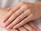 hand opal A three stone ring, the centre stone an old brilliant cut white diamond 4.6mm (est 0.38 carats) colour i-j, clarity Si, claw set in platinum.