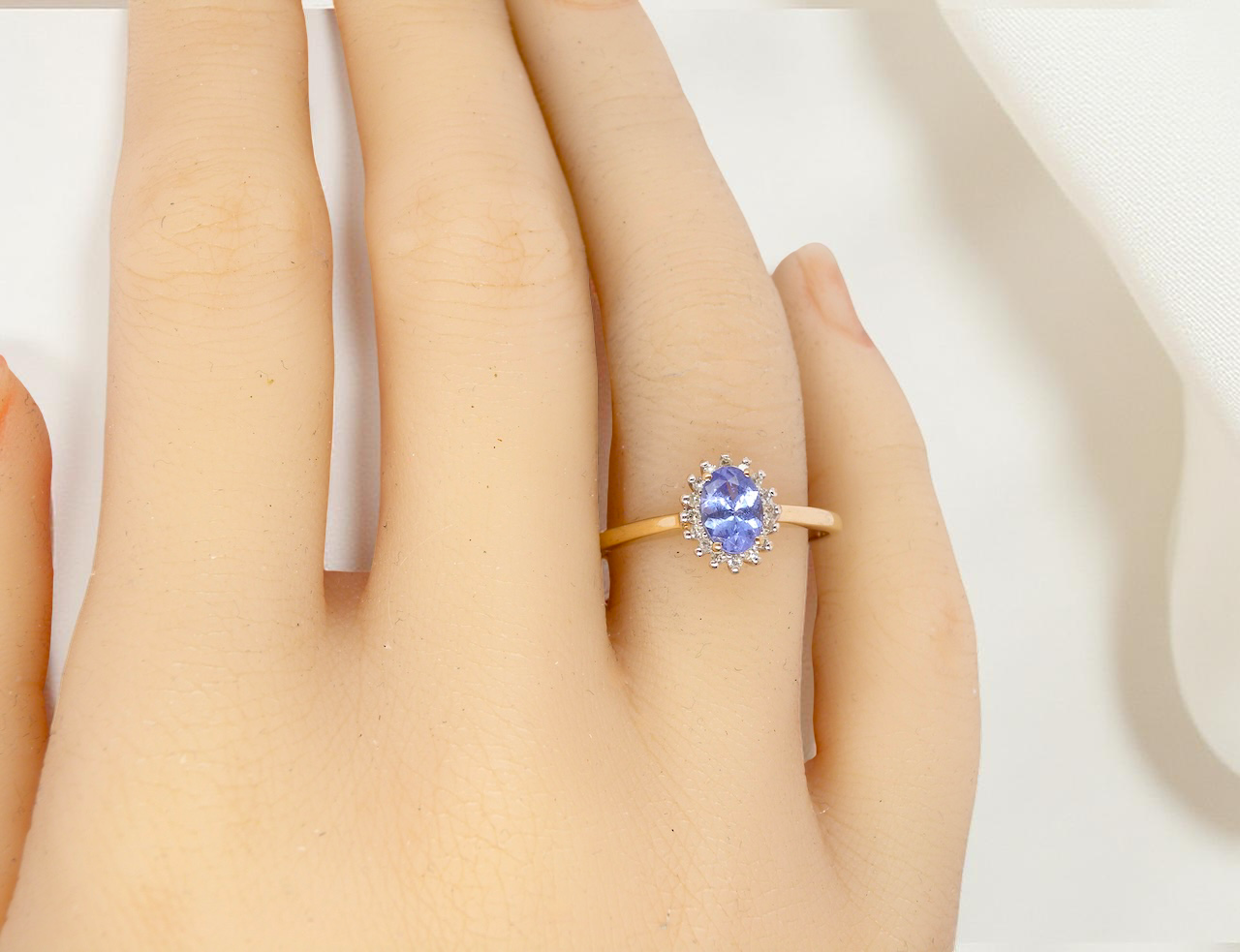 hand pretty cluster ring that features an oval cut tanzanite gemstone,