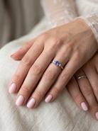 hsnd An 18 carat white gold three stone ring. Centre stone a round tanzanite 6mm diameter.
Each side a brilliant cut white diamond