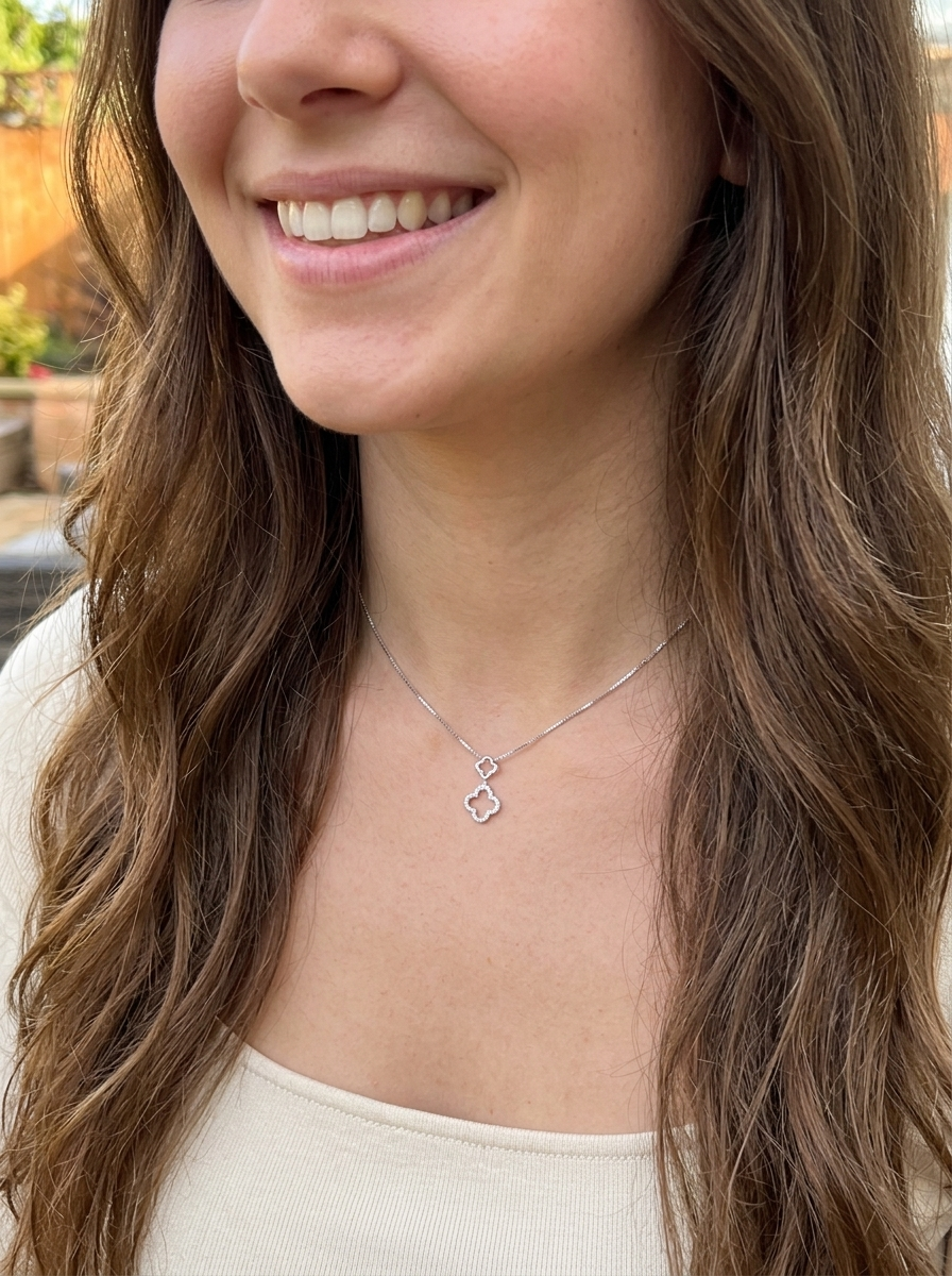 model A 9 carat white gold pendant in the 'Alhambra' style. Set with twenty four small white diamonds, carat total 0.12 carats.