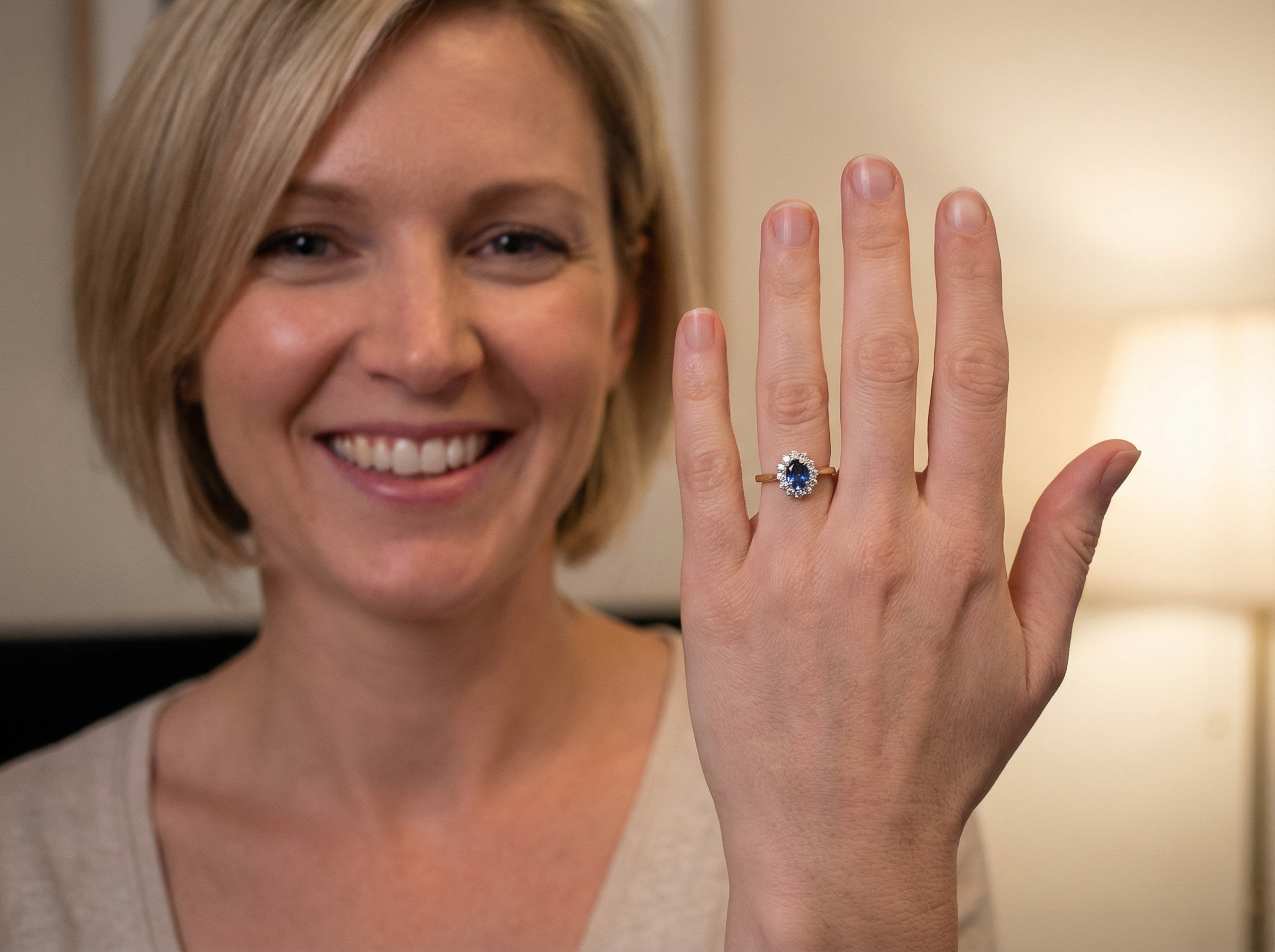 model A beautiful cluster ring featuring an oval-cut mid to dark blue sapphire measuring 7 × 5 mm (approximately ¾ carat).