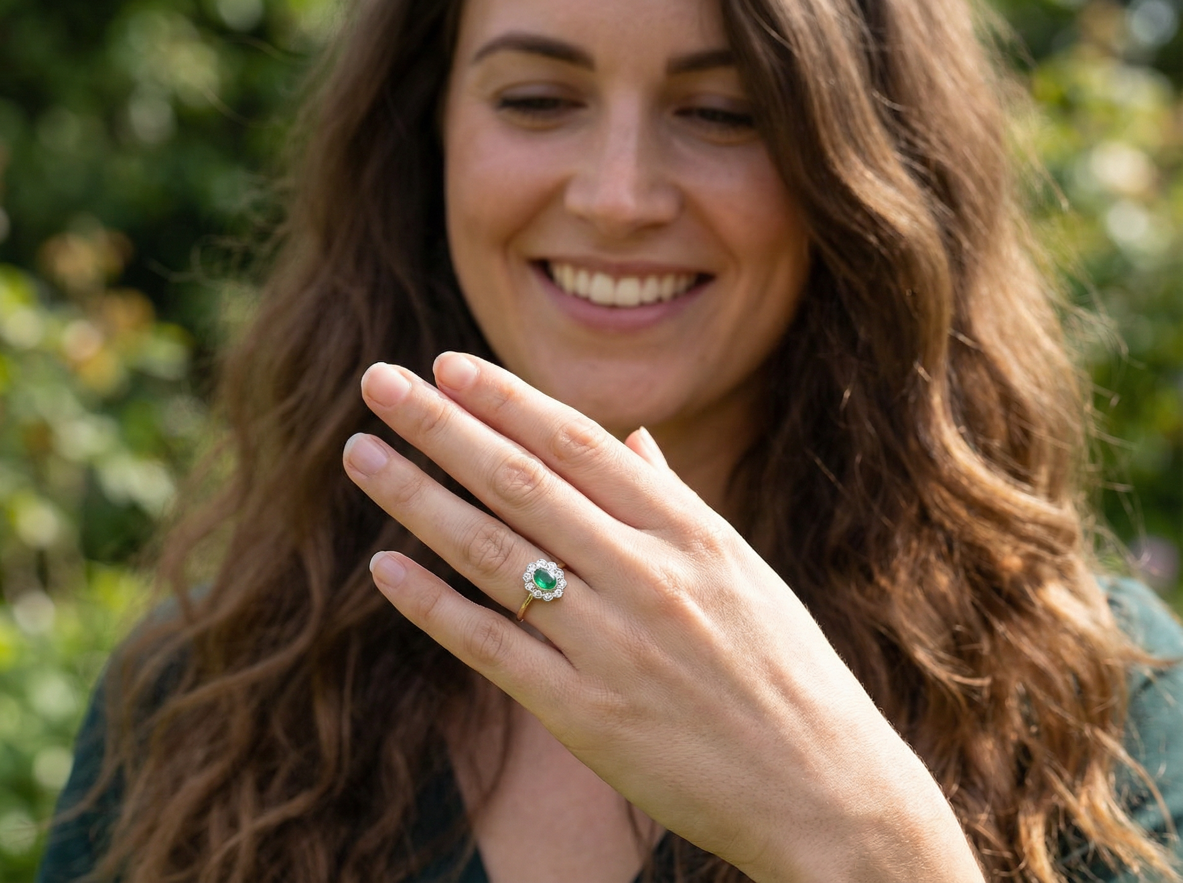 model A beautifully elegant cluster ring featuring a central oval-cut emerald, measuring 5 x 4mm (estimated 0.40 carats).