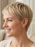 model A pair of earrings, half hoop style. The centre a channel set vertical row of emeralds and diamonds, 