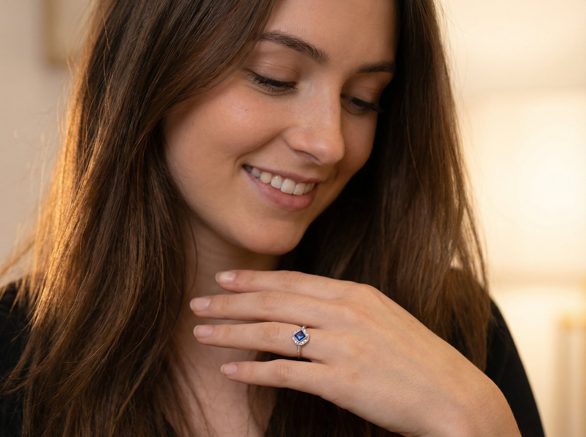 model A very pretty Art Deco cluster ring. To the centre a mid to dark blue sapphire, square cut but set as a 'diamond shape'. Measures 5x5mm, rim setting.