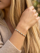 model An elegant line bracelet set with fourteen oval opals, each measuring approximately 5 x 3 mm, displaying a pleasing and lively play of colour.
