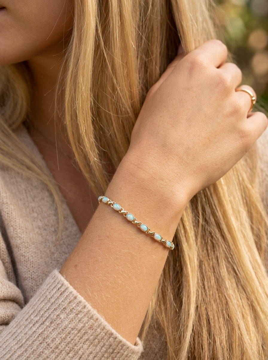 model An elegant line bracelet set with fourteen oval opals, each measuring approximately 5 x 3 mm, displaying a pleasing and lively play of colour.
