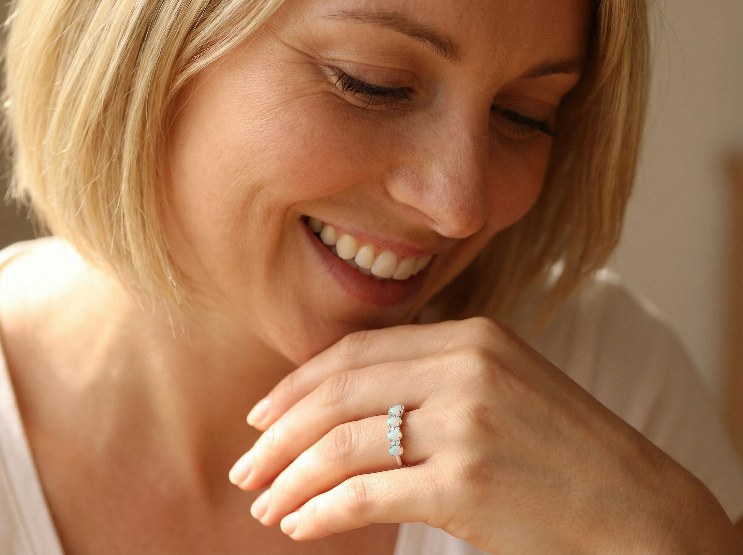 model An elegant opal and diamond half hoop ring, featuring five oval opals with lively play of colour. Each opal measures 5 x 3mm, with an estimated total opal weight of approximately 0.75 carats, all claw set to maximise light and colour.