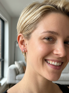 model An unusual pair of earrings. The design like a French horn is fashioned in 18 carat white gold, measures 18x 10mm.