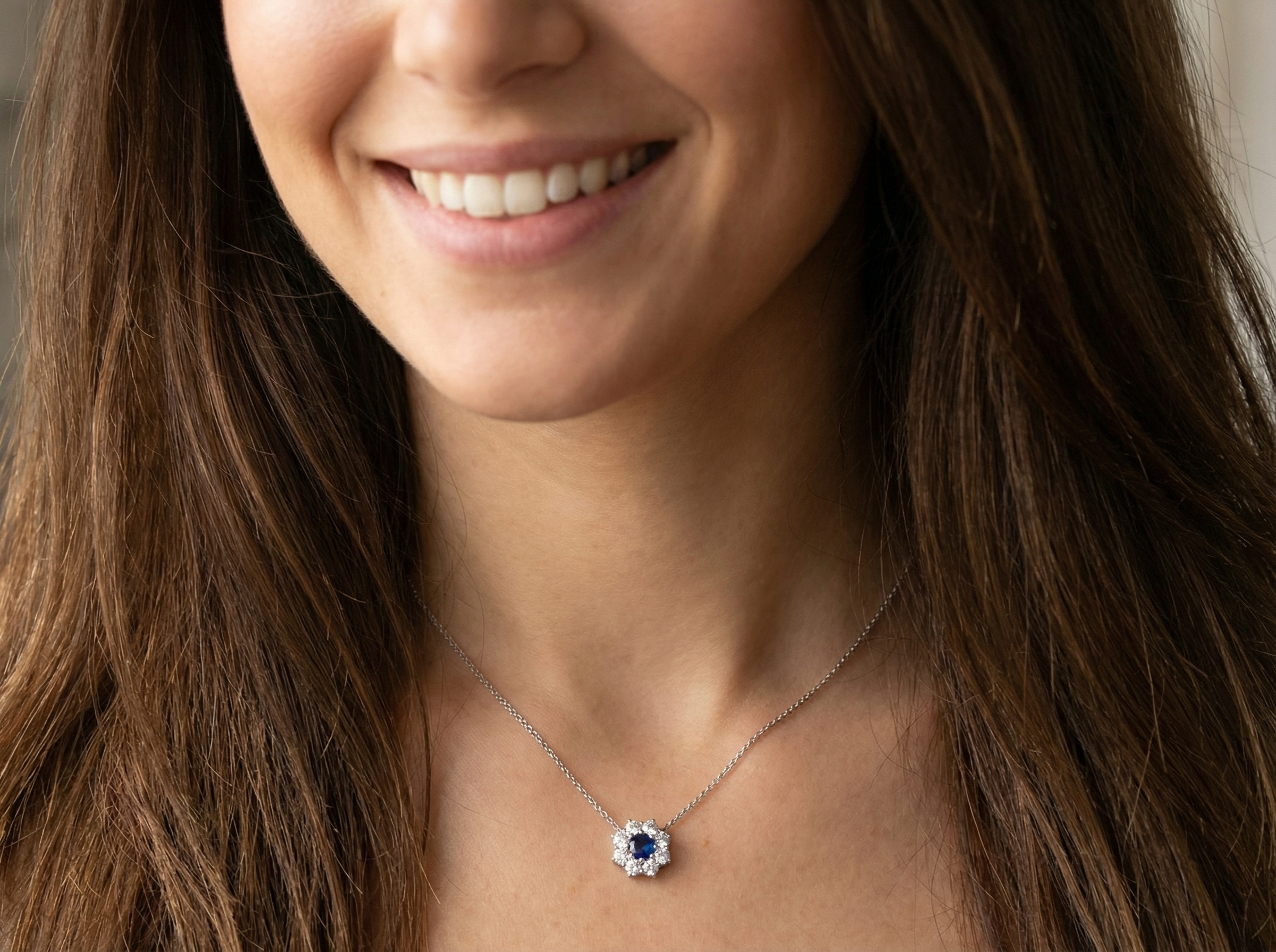 model pendant with a vibrant blue sapphire at its centre.