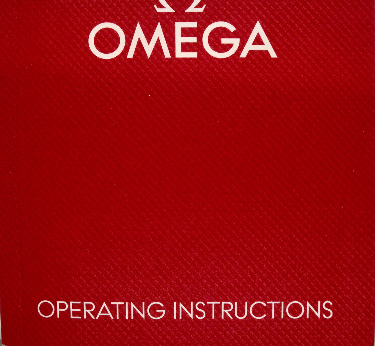 A close-up of a red textured Omega box or booklet cover with the word OMEGA at the top and OPERATING INSTRUCTIONS at the bottom in white text.