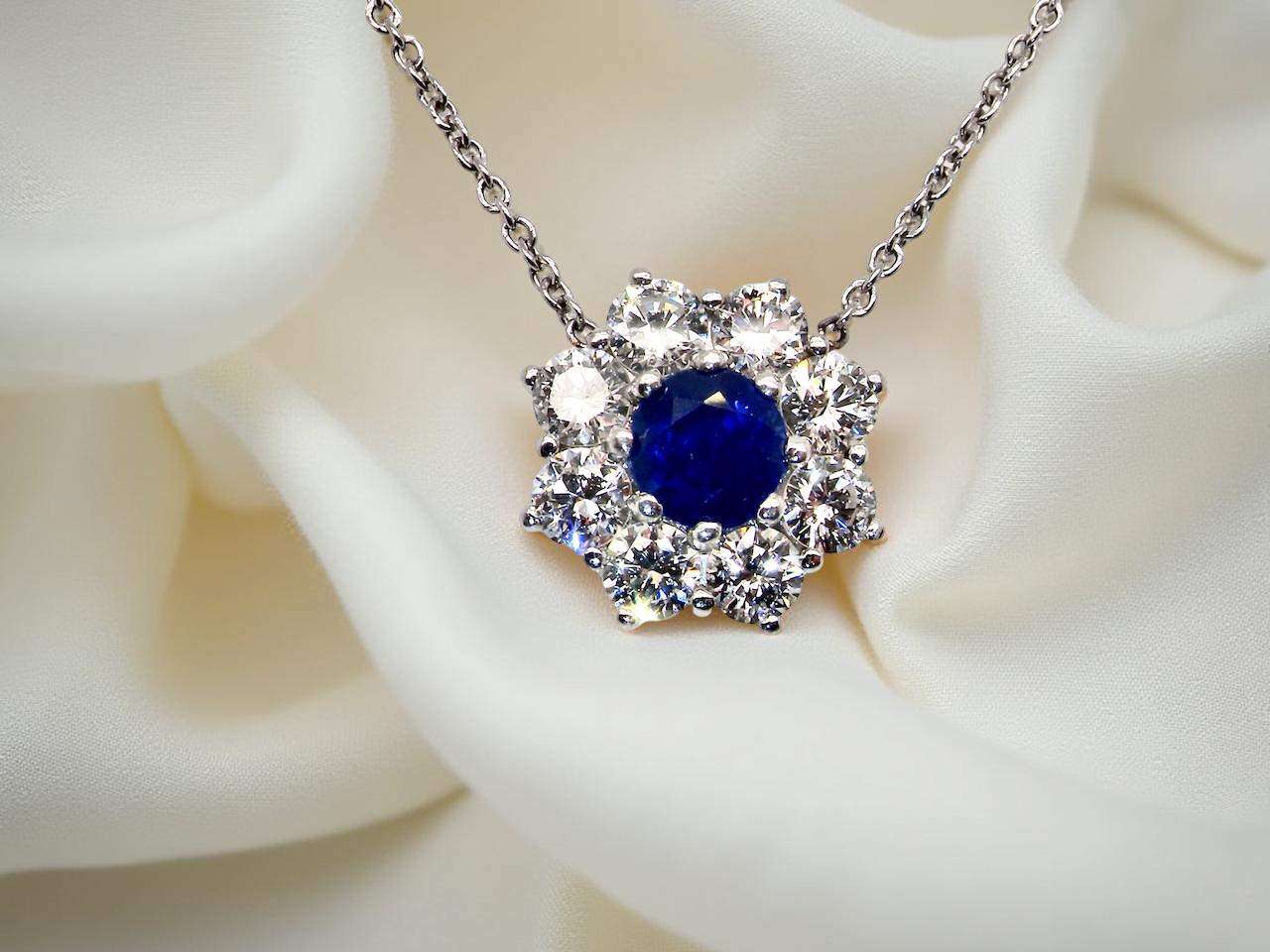 pendant with a vibrant blue sapphire at its centre.