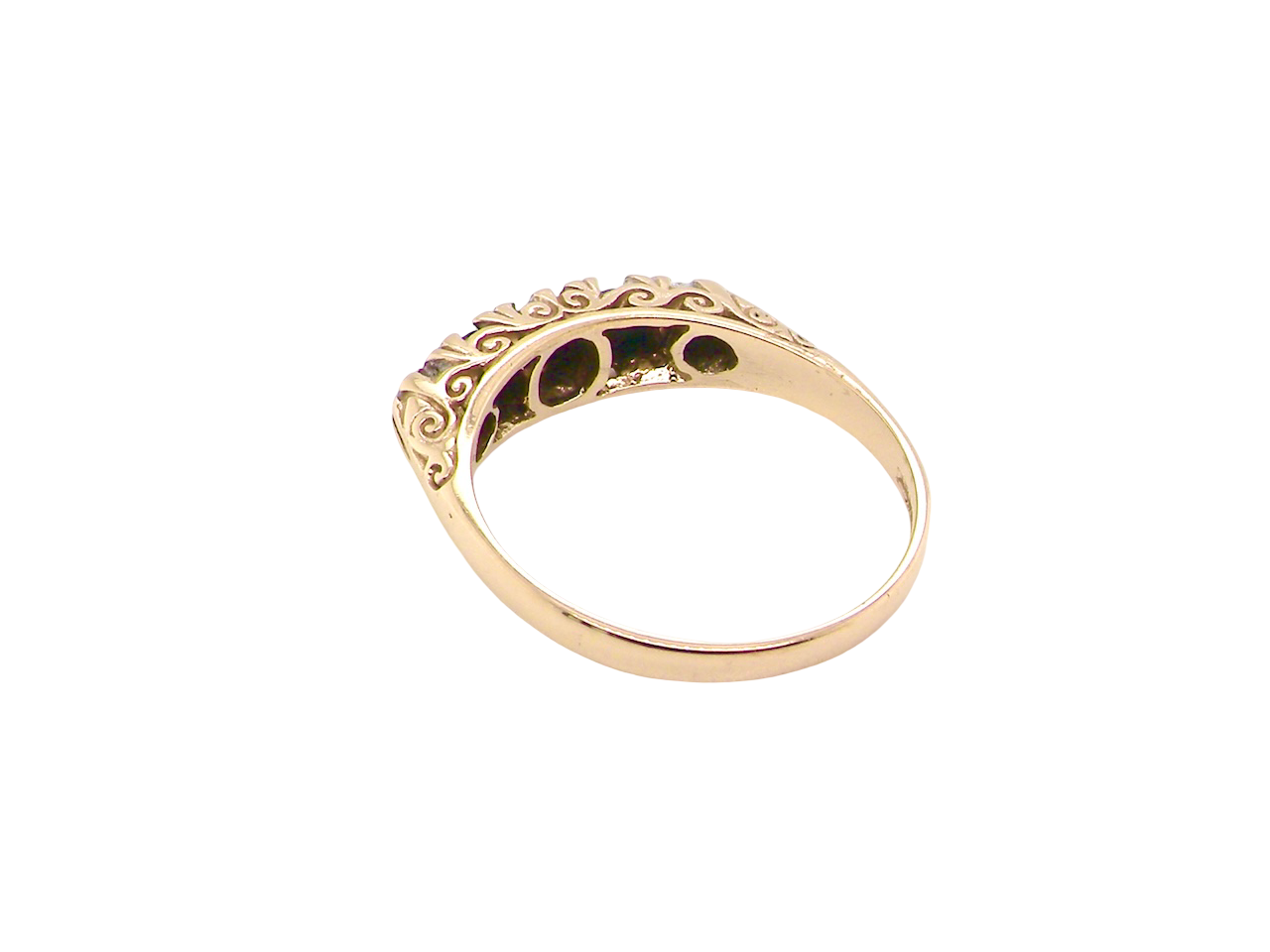 Gold ring with intricate design on a white background