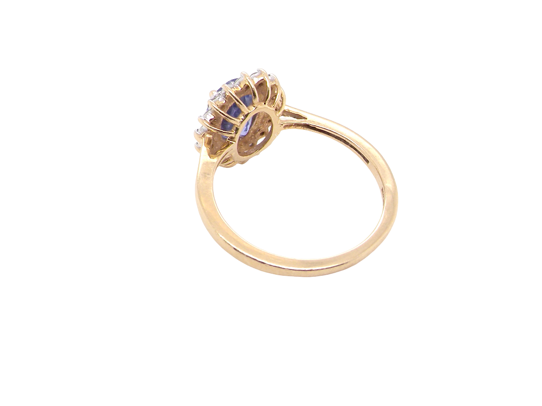 rear A 14 carat gold cluster ring. Features to the centre an oval cut cornflower blue sapphire, 8x6mm (est 1.25 carats), four claw setting.
