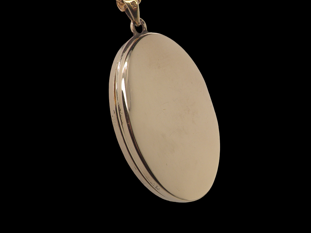 rear A 9 carat gold locket*, oval shaped, measures 30x20mm, depth 5mm.&nbsp;