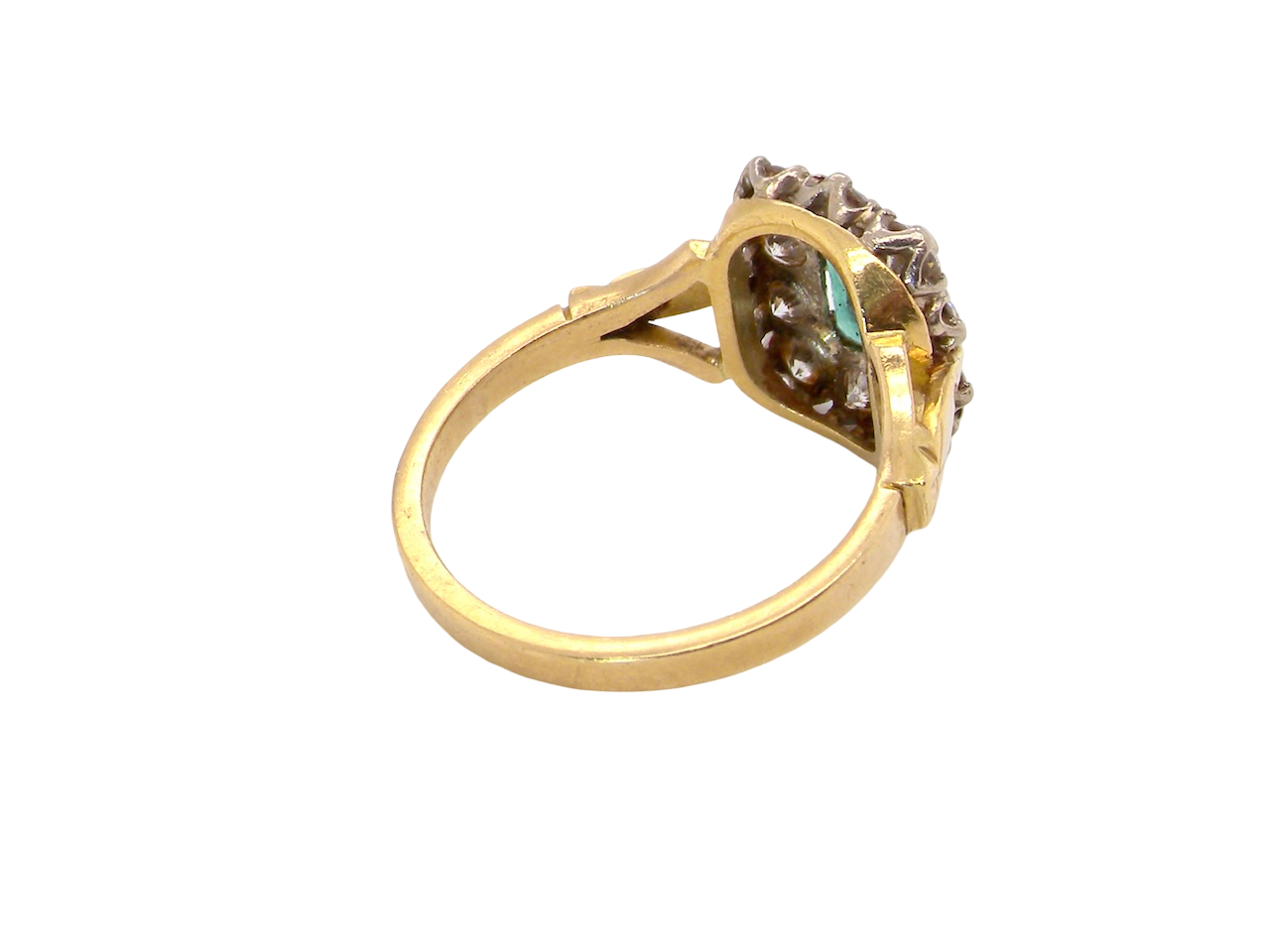 rear A cluster ring that features a rectangular emerald centre stone, 7x5mm . Deep green colour, natural inclusions that can be seen under an eye glass, but not easily visible via the naked eye.