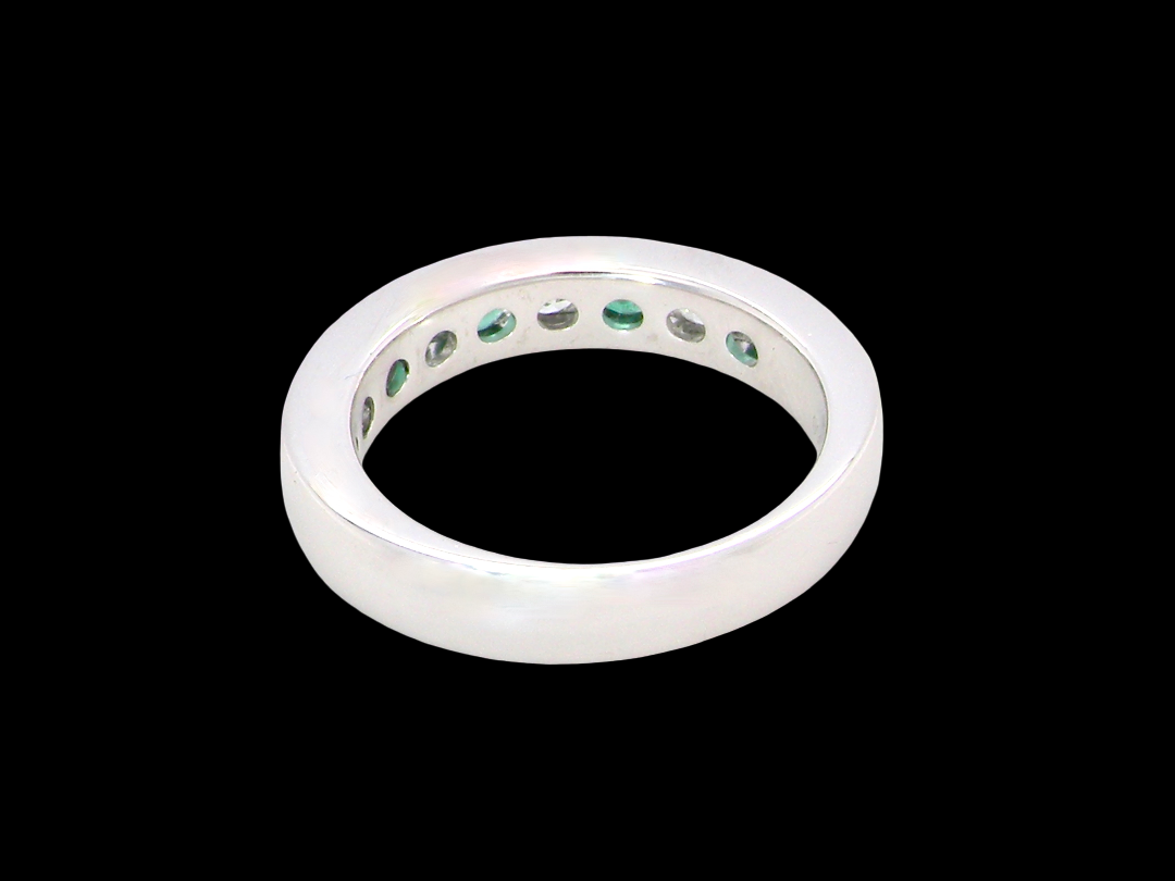 rear A fine platinum half hoop eternity ring. This is a new ring*. Channel set gem stones, five bright green emeralds 2.6mm each (0.54 carats total)