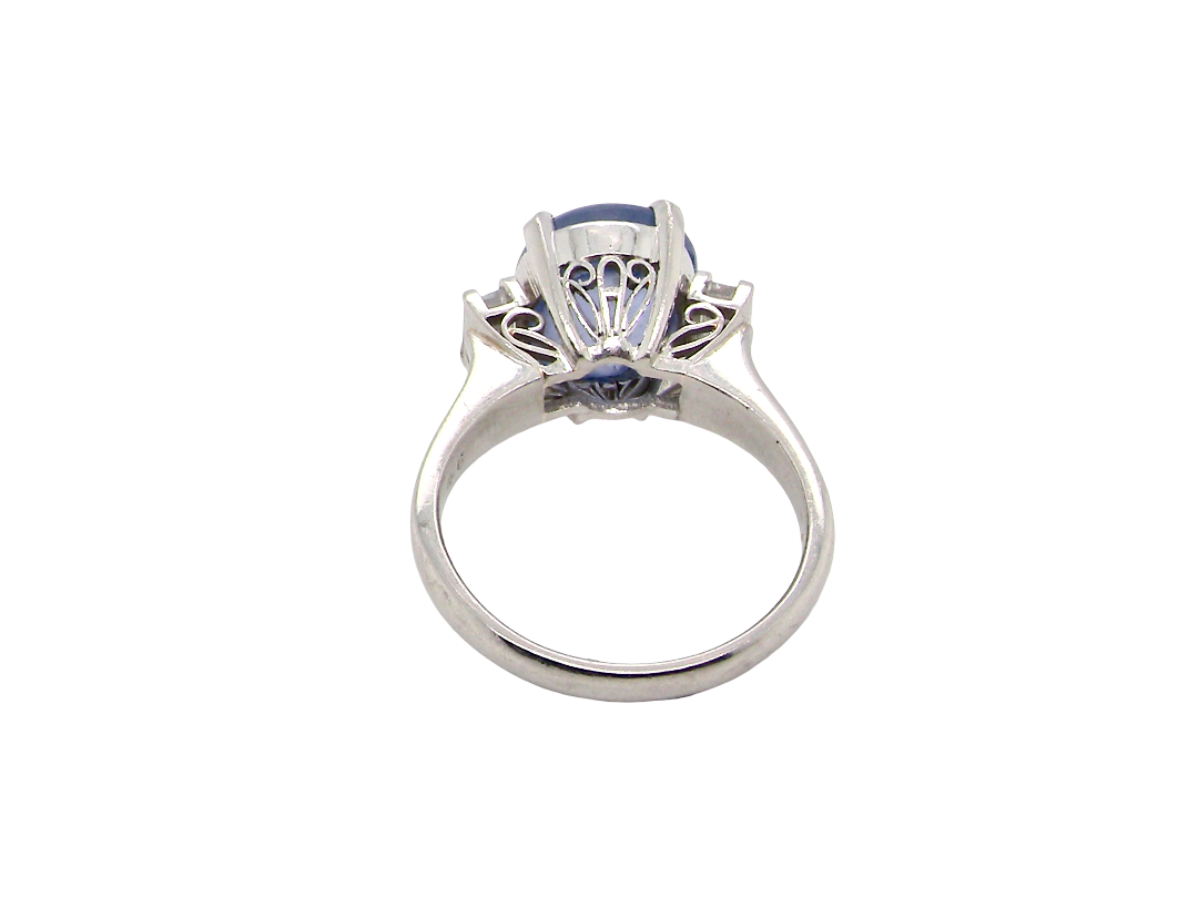 rear A fine platinum* ring. Features a lovely sky blue sapphire with 'star sapphire ' chatoyancy , measures 10x9mm, (est 4 carats) held by four claws, cabouchon cut