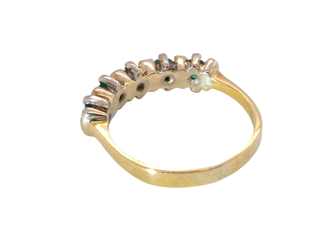 rear A half hoop ring, stamped 750 (testing as 18 carat gold)&nbsp;

Set with alternate gemstones, five bright green emeralds