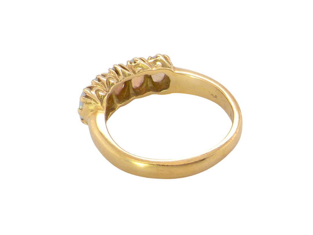 rear A lovely five stone ring. Set with five oval white opals, each 5x3.5mm, good play of colour on all.

Carved head 