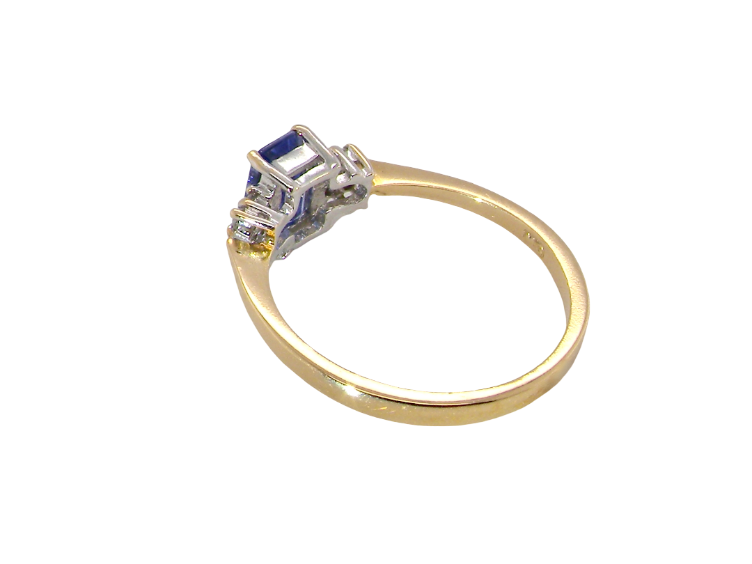 rear A three stone 18 carat gold ring. Features a rectangular tanzanite centre stone 6x4mm (est 0.50 carats)