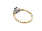 rear A three stone 18 carat gold ring. Features a rectangular tanzanite centre stone 6x4mm (est 0.50 carats)