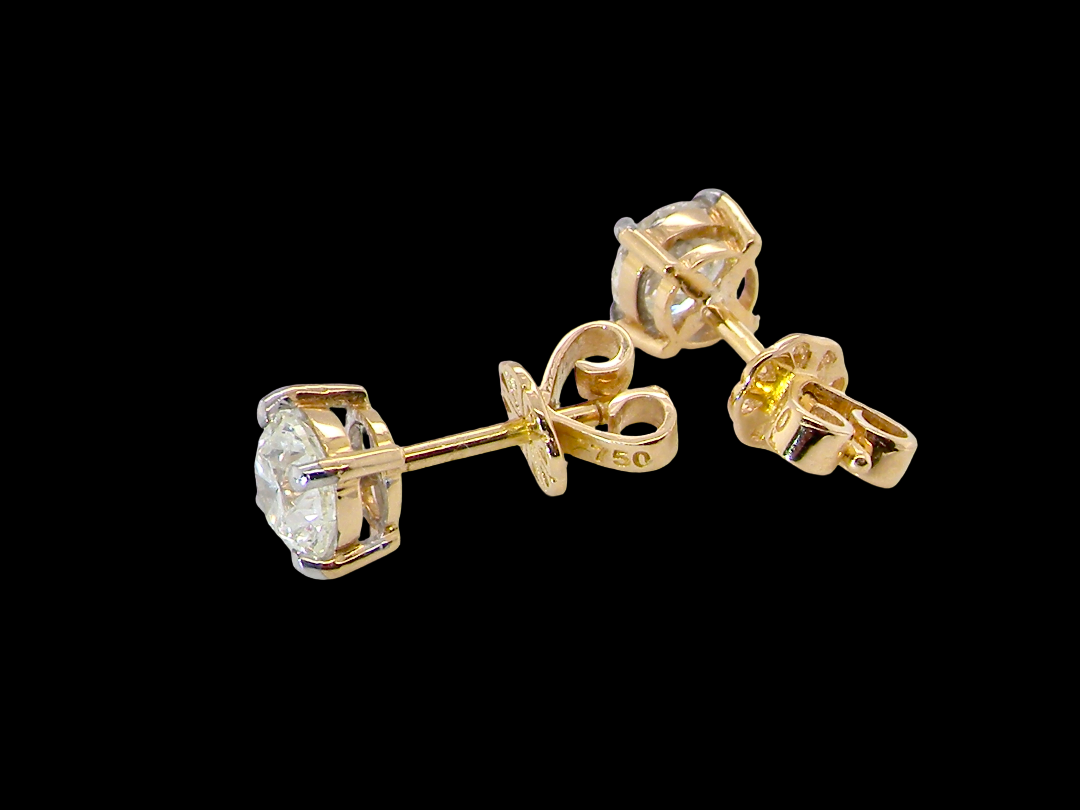 A pair of yellow gold stud earrings with round-cut clear gemstones in a halo setting, shown from multiple angles against a solid black background.