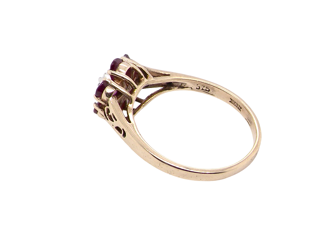 rear A very pretty 9 carat gold cluster ring. The centre stone a small illusion set diamond, 1.3mm

Surrounded by six pear shaped raspberry red rubies,