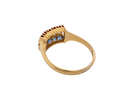 A vintage gold ring with a semi-circular cluster setting featuring three light blue round-cut stones and a row of small red stones above, shown on a plain white background.