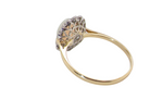 A yellow gold ring with a decorative filigree head set with small clear stones, shown on a plain white background.