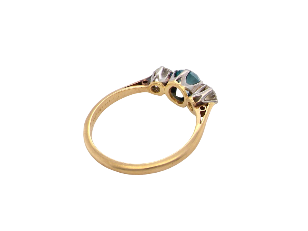 rear A vintage three stone ring. Centre stone, a round 5.8mm natural blue zircon.

To each side an old brilliant cut white diamond 4mm round (est 0.25 carats). Colour i-j, clarity Si.