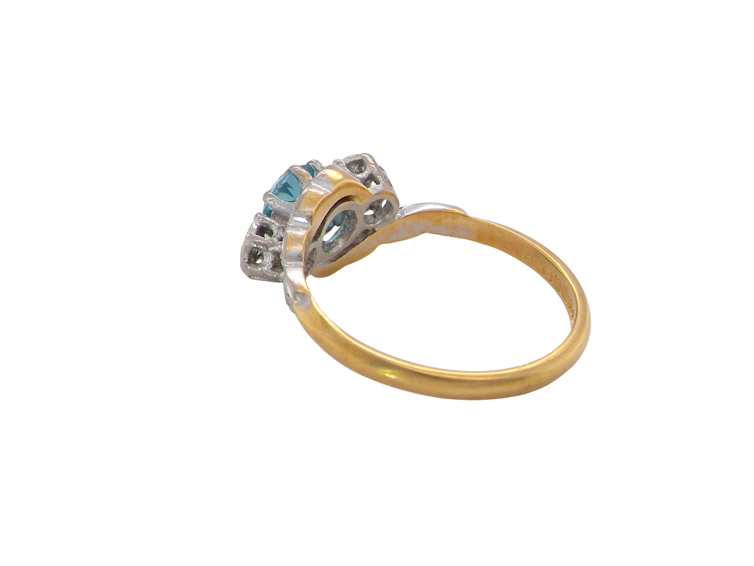 rear A vintage three stone ring, cross over style and features a round 6mm&nbsp; natural blue zircon centre stone