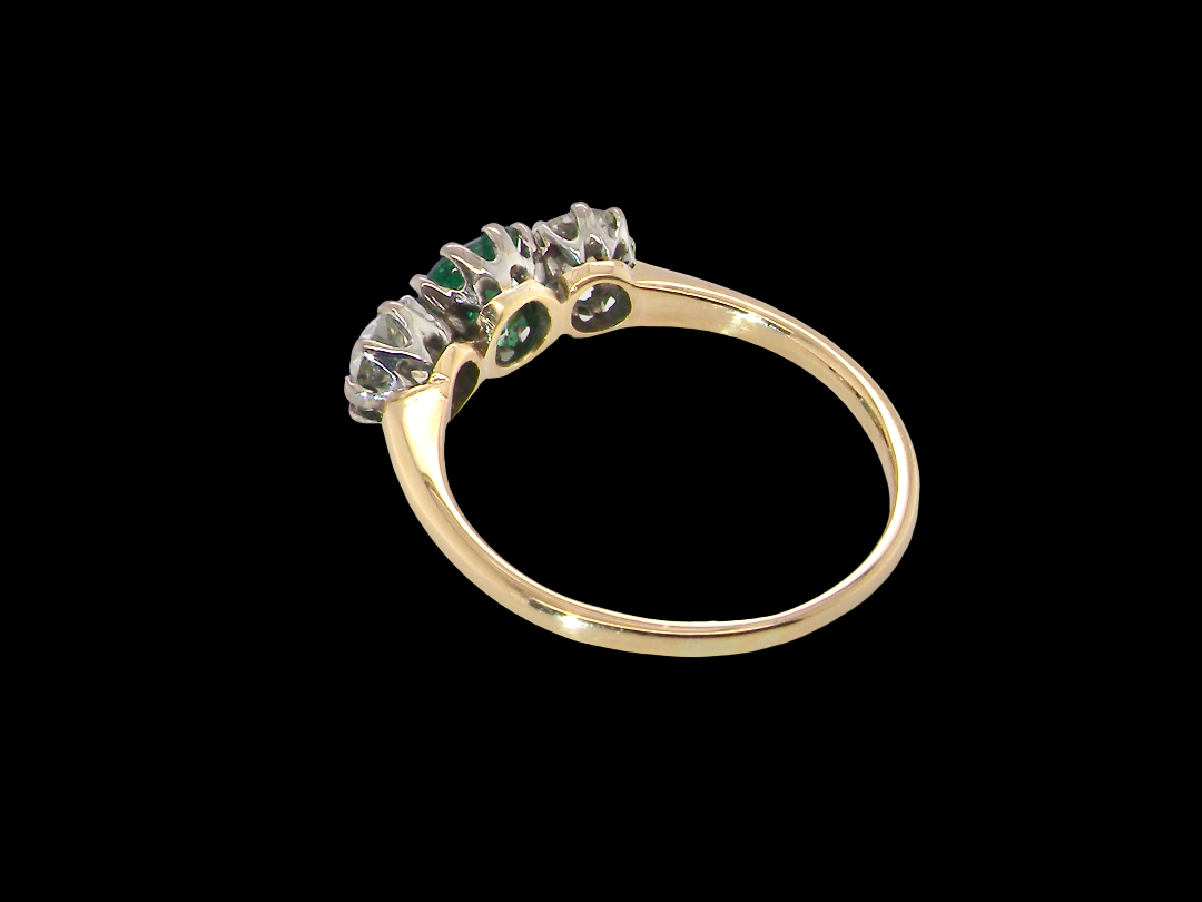 rear A vintage trilogy ring. Centre stone a step cut emerald, 6.5x5.5mm (est .75 carats). The emerald is dark green. 