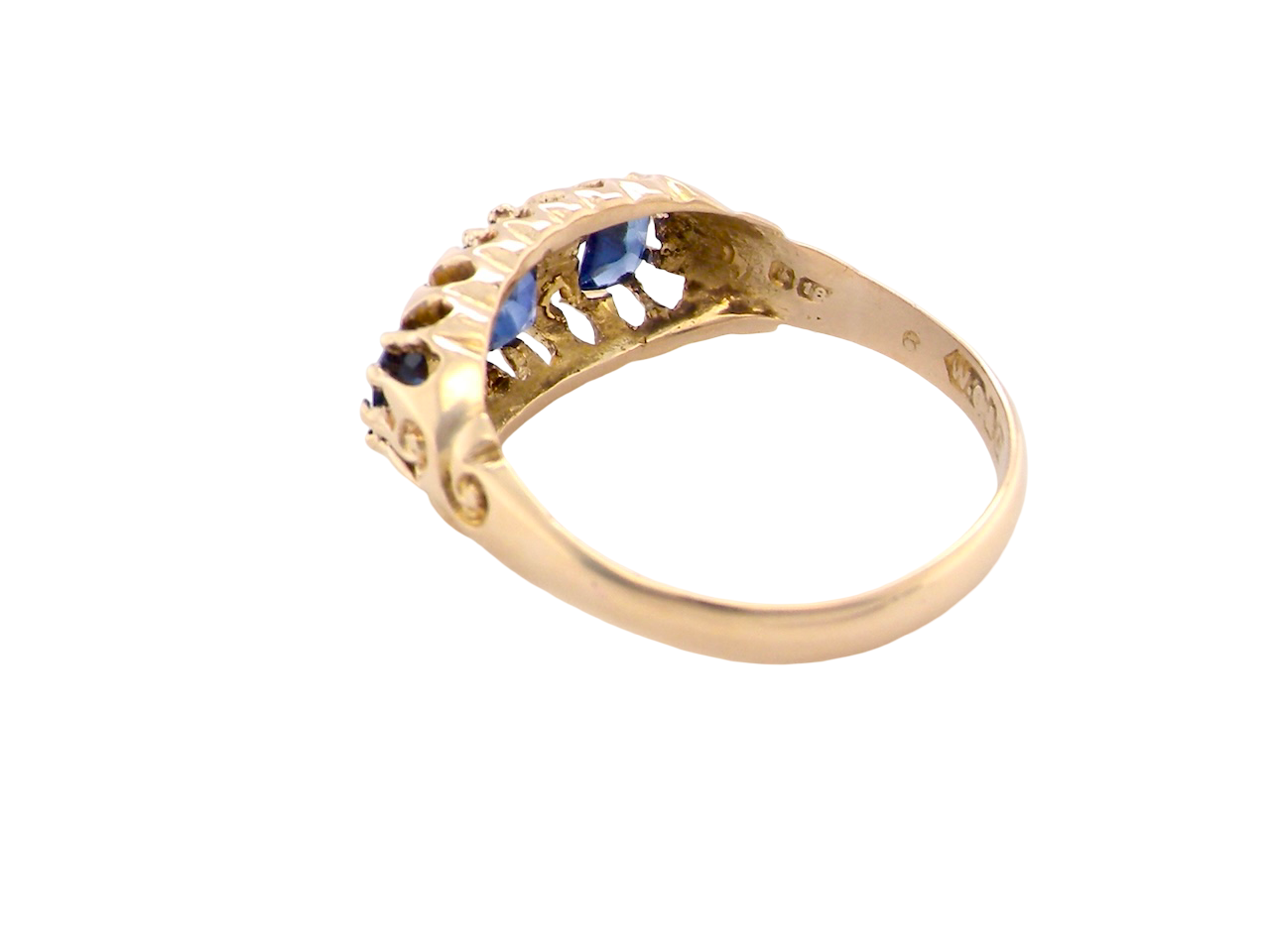 rear An 18 carat gold antique boat shaped ring. Features three oval to cushion cut sapphires, centre 6x5mm, each end 5x3mm. Mid to dark blue