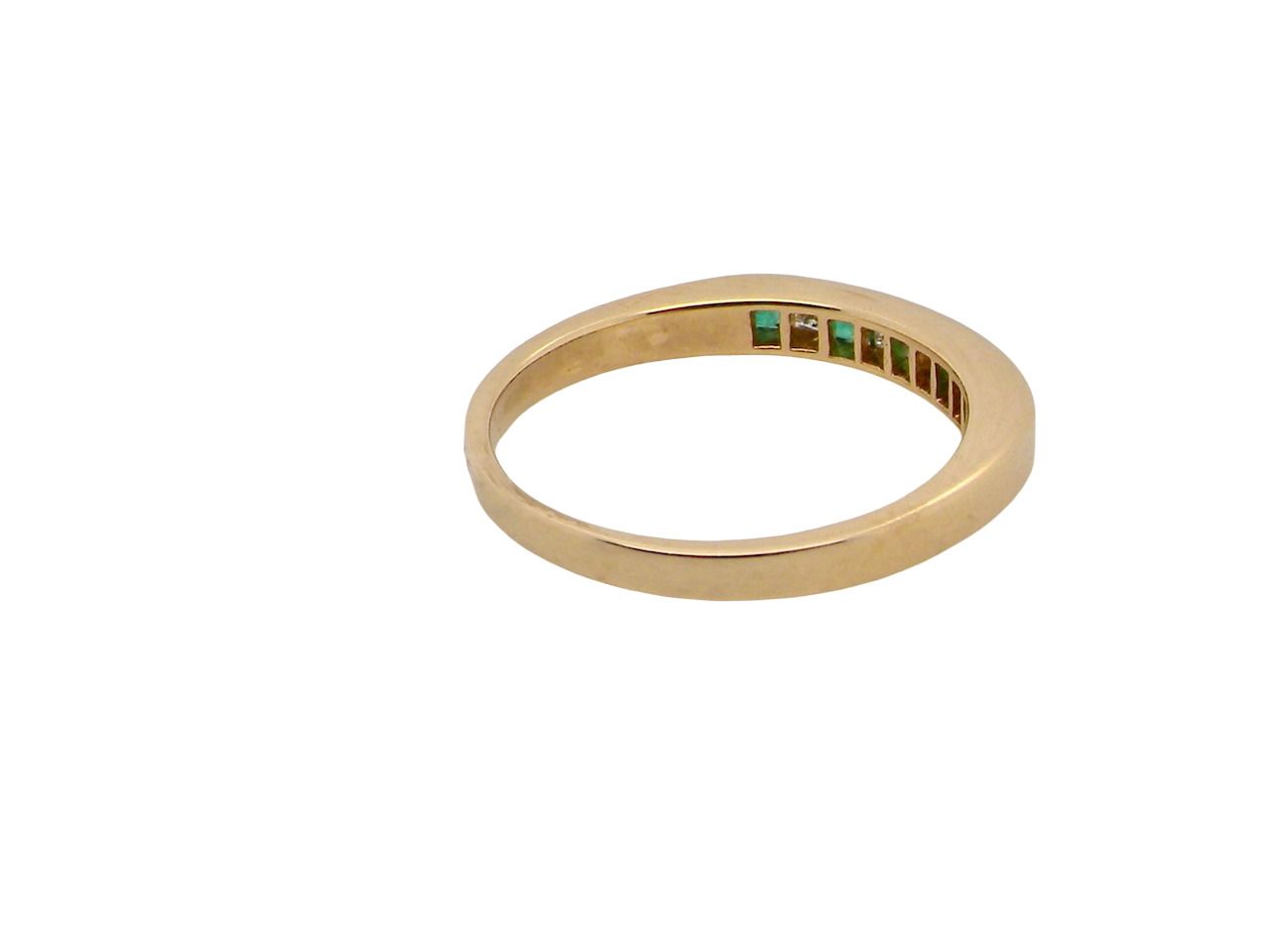 Gold ring with green gemstones on a white background
