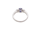 rear An 18 carat white gold three stone ring. Centre stone a round tanzanite 6mm diameter.
Each side a brilliant cut white diamond