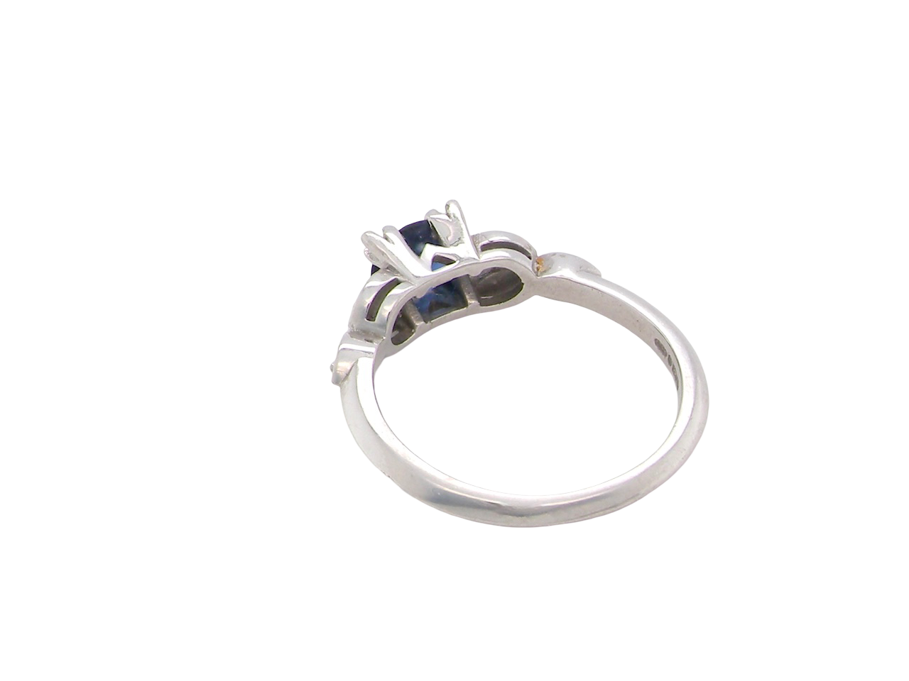 rear An elegant vintage-style platinum ring showcasing a beautifully proportioned round sapphire with a soft mid to light cornflower blue hue. The sapphire measures 5.6mm in diameter (approx. 0.80 carats) 