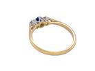rear The classic trilogy ring, this features to the centre a round mid to dark blue sapphire and each side a brilliant cut white diamond