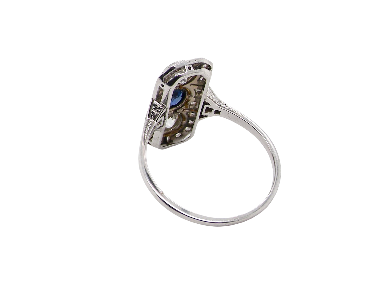 rear The plaque design has at its centre a mid to dark blue sapphire, 5x4mm (est 0.40 carats) mille grain set. Above and below to Old European Cut white diamonds. Each one estimated at 0.40 carats (4.8mm) Colour H-j, clarity Si.
