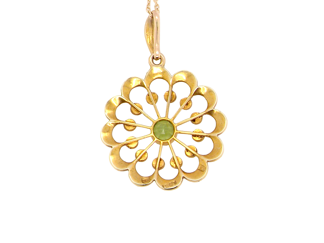 rear pendant from the Edwardian- Age of Elegance-

The centre stone- a round peridot 5mm diameter, mille grain set. A satellite perimeter of twelve seed pearls, each 2.4mm. The outside border is scalloped shaped and each crescent is set with tiny seed pearls.